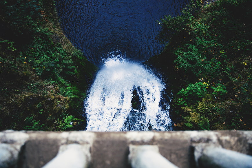 Aerial View of Waterfall Cascading into Deep Blue Pool