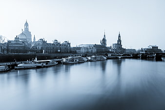 Long exposure blue monochrome view of Dresden skyline and boats