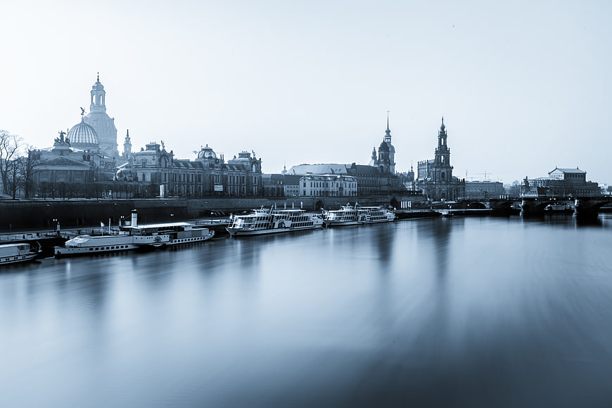 Long exposure blue monochrome view of Dresden skyline and boats