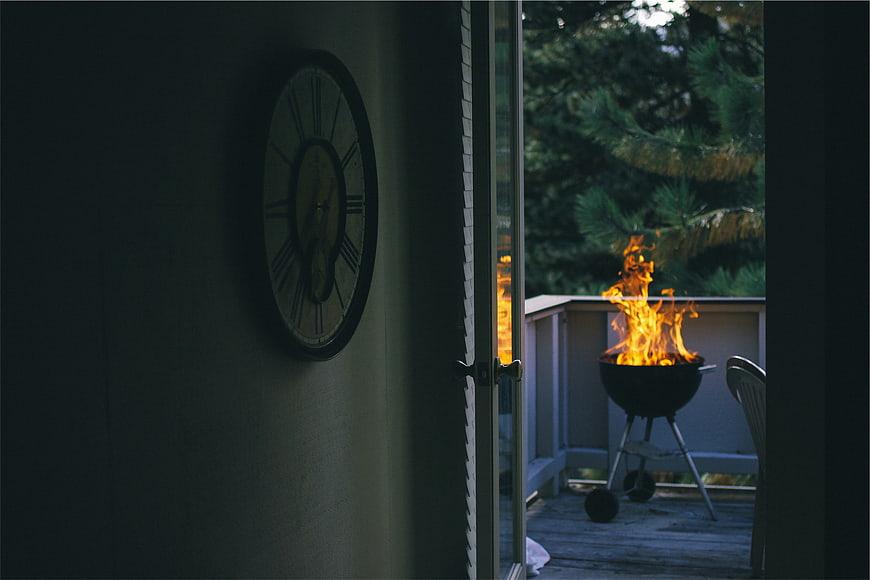 Grill Fire on Deck Viewed Through Glass Door