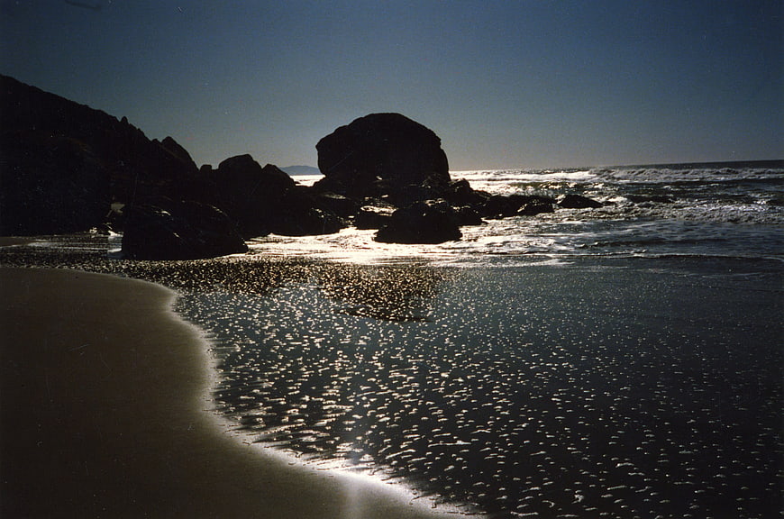 Sunlit Rocky Beach Seascape with Glowing Water