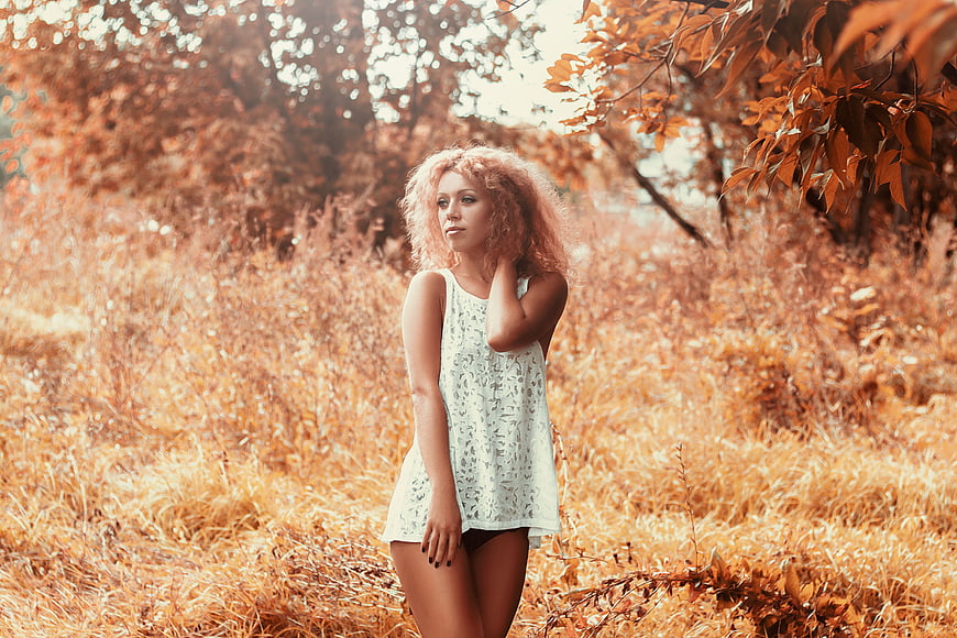 Young Woman with Curly Hair in Autumn Forest