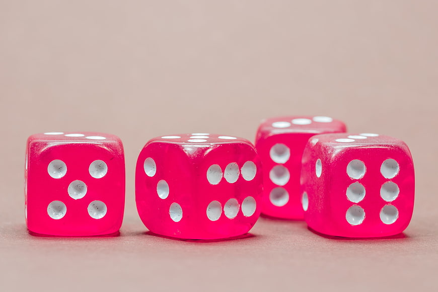 Pink translucent dice on beige background