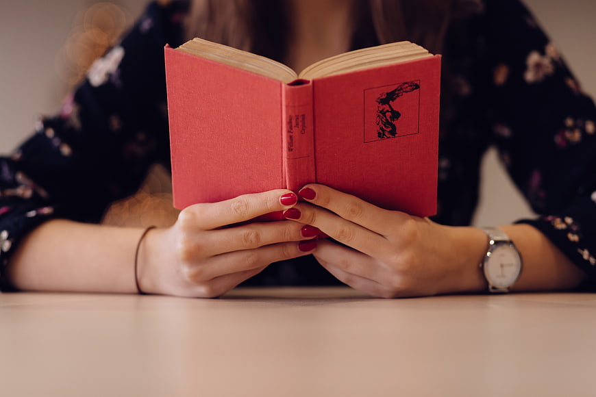 Woman Reading Red Book with Red Nail Polish