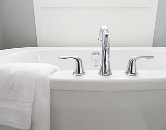 Modern white bathtub with chrome faucet and white towel