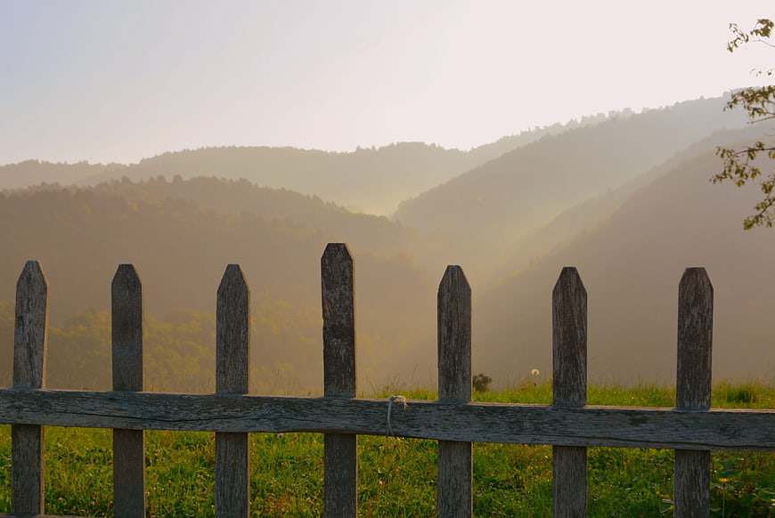 Rustic wooden fence in front of misty mountain landscape