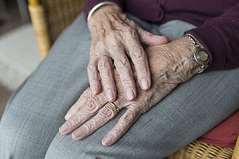 Close-up of elderly woman's wrinkled hands resting on lap