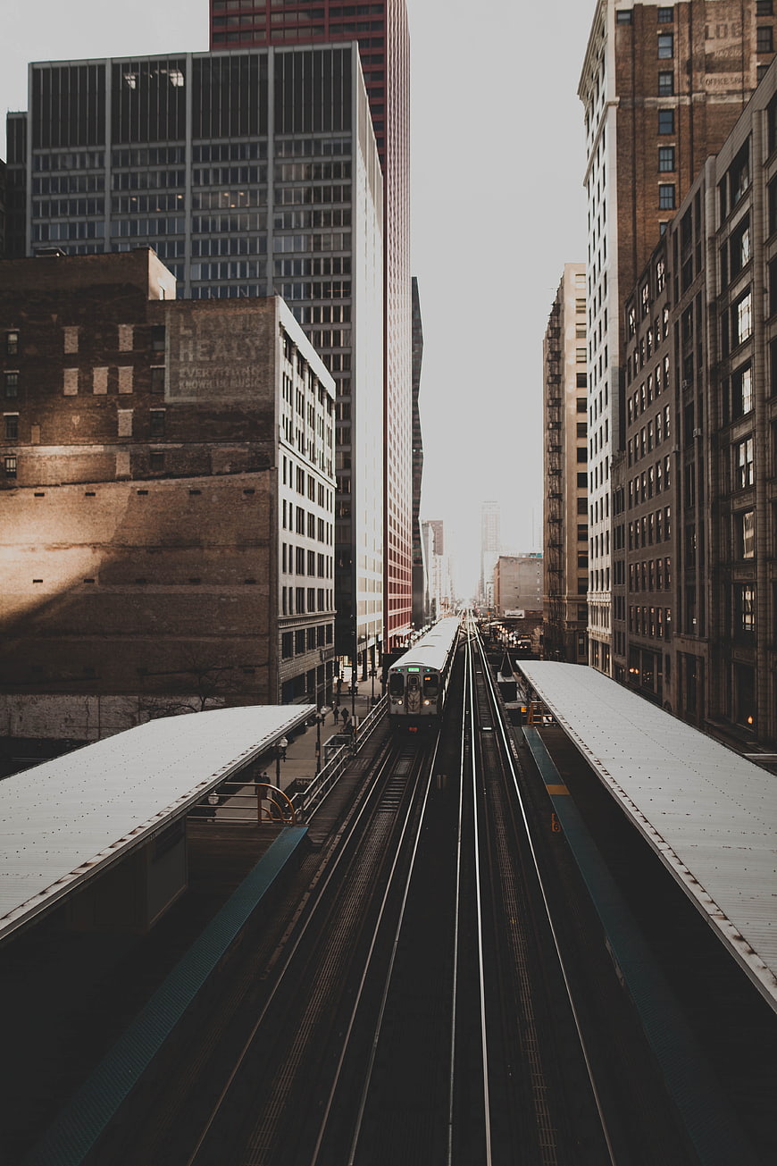Elevated train tracks in urban city canyon with tall buildings