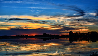 Dramatic Sunset Reflection Over Calm Lake With Silhouette