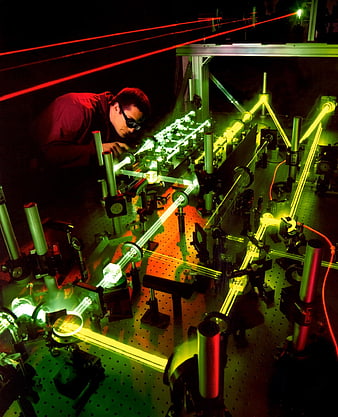 Physicist conducting complex laser optics experiment in dark laboratory
