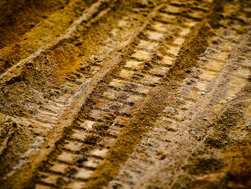 Close-up of tire tracks in textured sandy soil