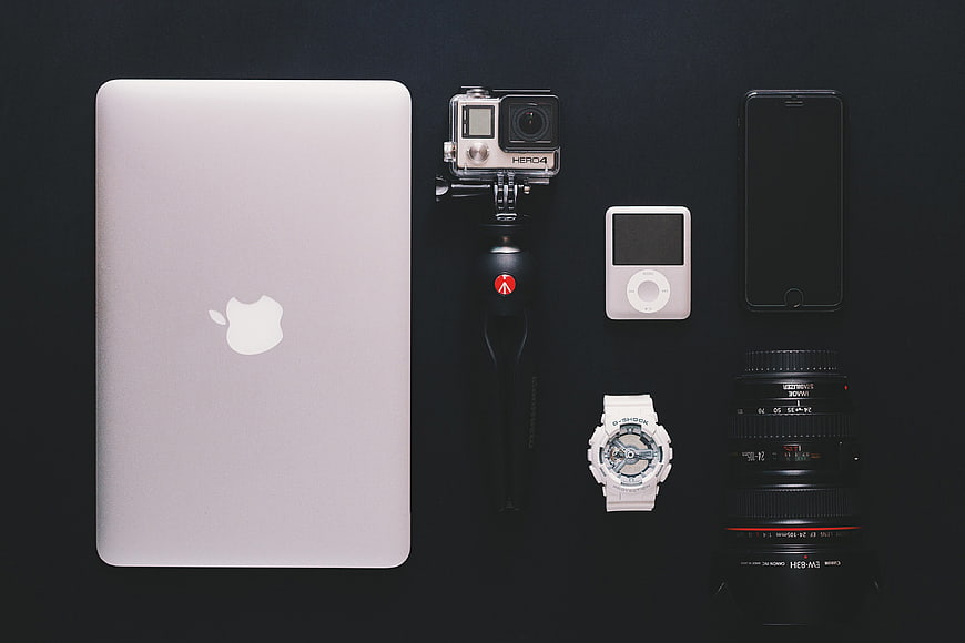 Flat lay of photography gear and tech gadgets on black background