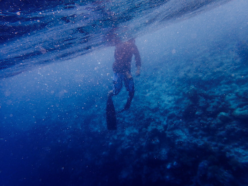 Underwater shot of a snorkeler swimming over coral reef