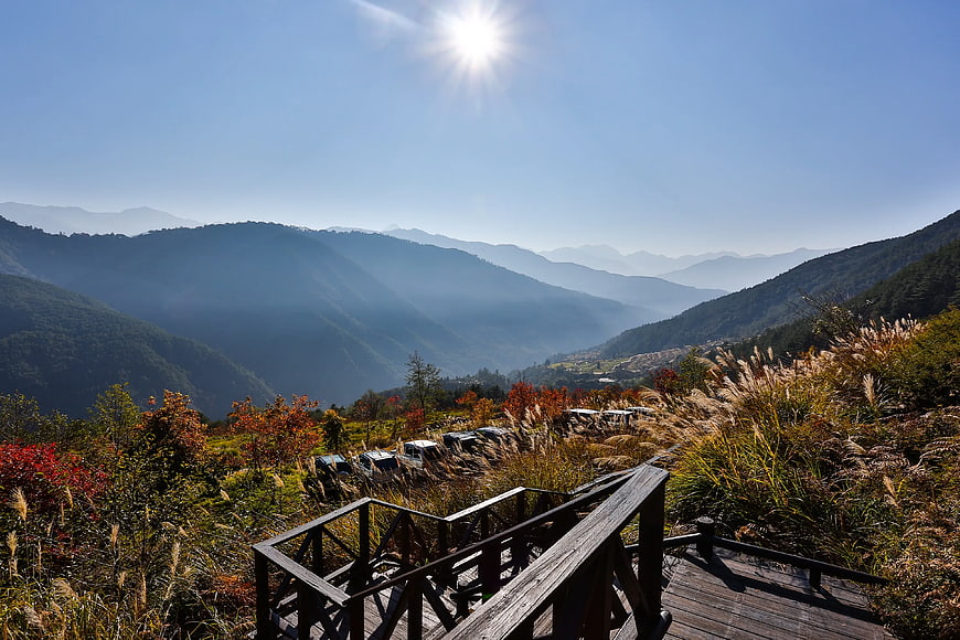 Wooden Walkway Overlooking Misty Mountain Valley in Autumn