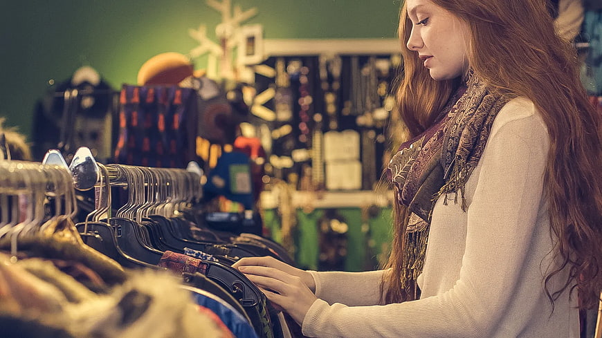 Young woman browsing clothes in a vintage boutique