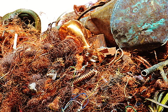 Pile of rusty copper wire and scrap metal in a recycling yard
