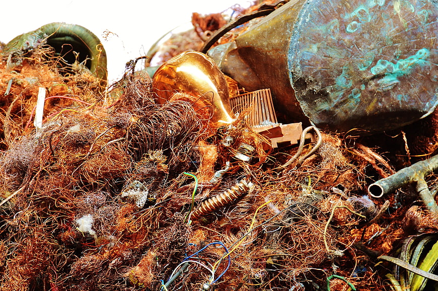 Pile of rusty copper wire and scrap metal in a recycling yard