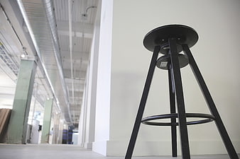 Low angle view of black industrial stool in modern warehouse