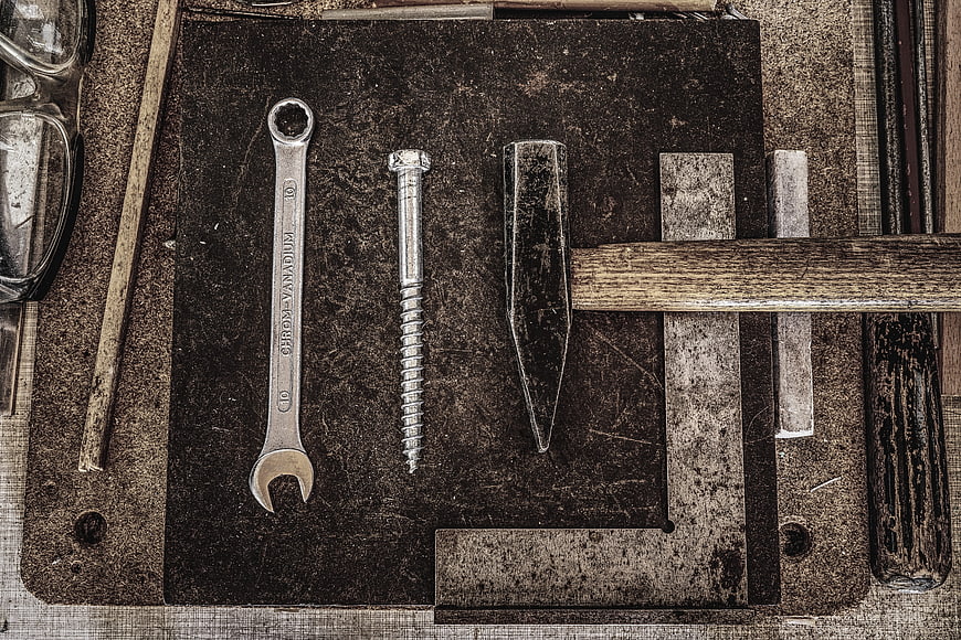 Vintage tools on dark textured workbench background