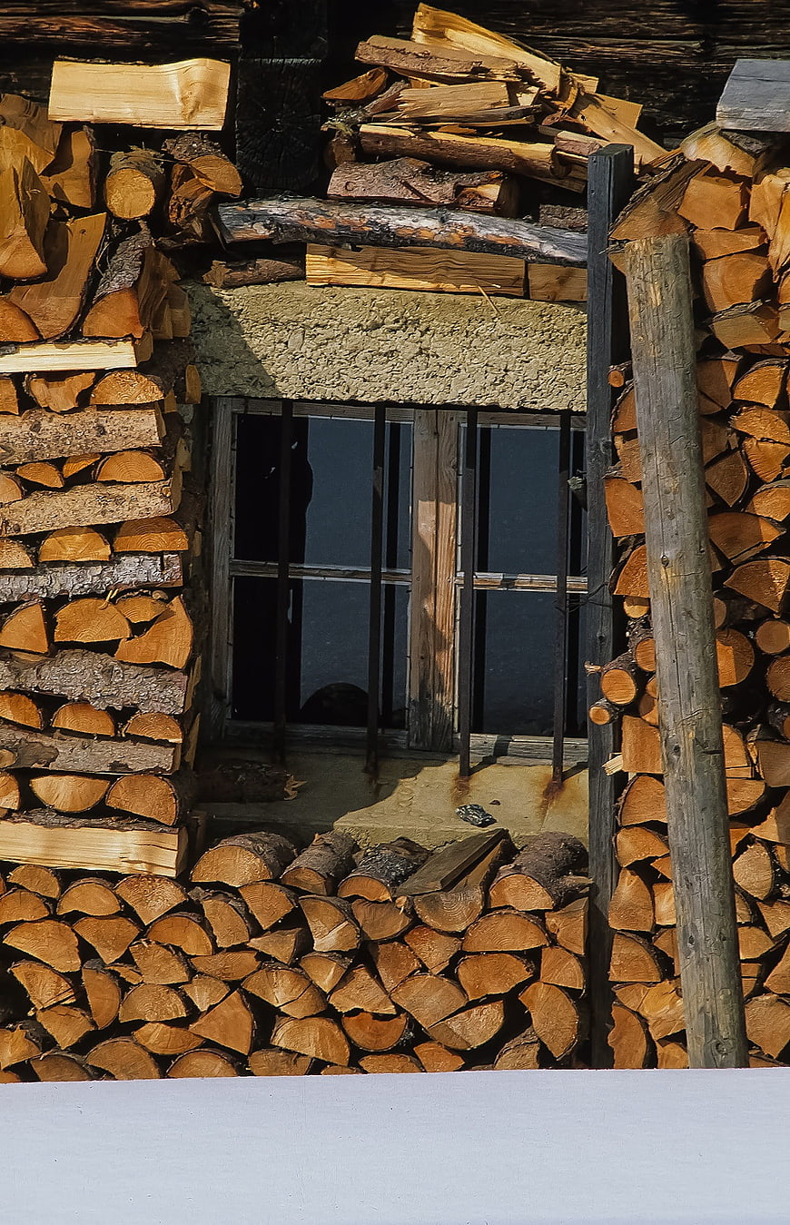 Stacked Firewood Logs Framing a Rustic Window