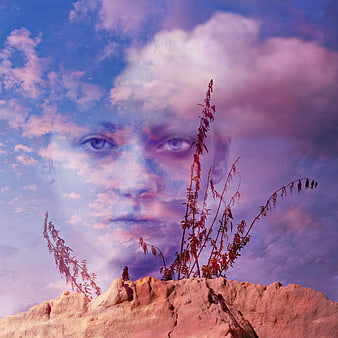 Surreal double exposure portrait of a woman's face blended with clouds and desert plants
