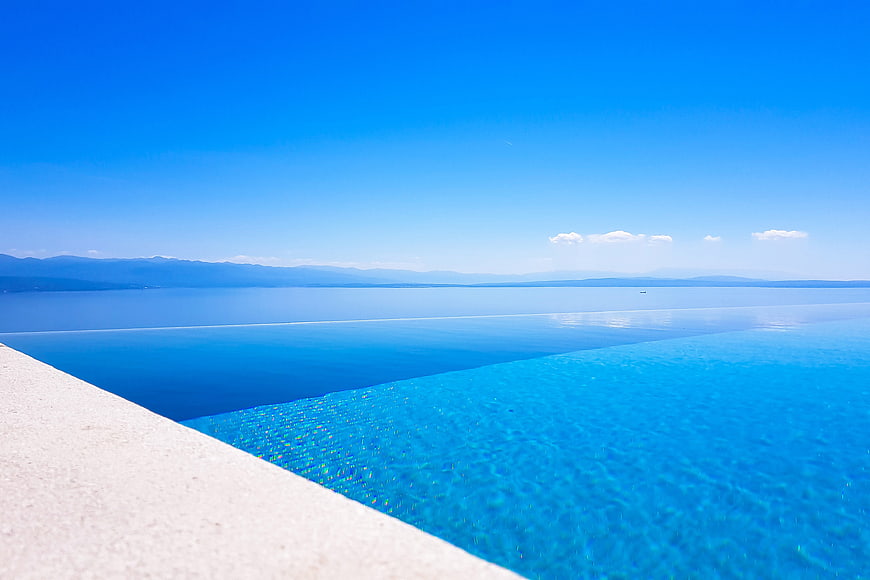 Infinity Pool Overlooking Calm Blue Lake and Mountains