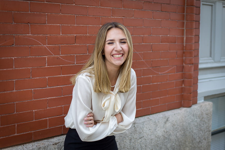Smiling Business Woman in White Blouse Against Brick Wall