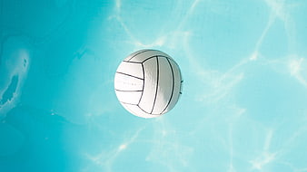 White Volleyball Floating in Blue Swimming Pool Water