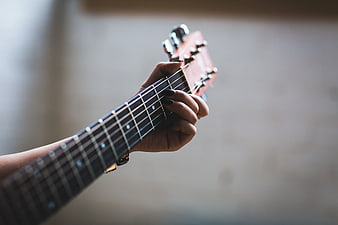 Close-up of hand playing acoustic guitar