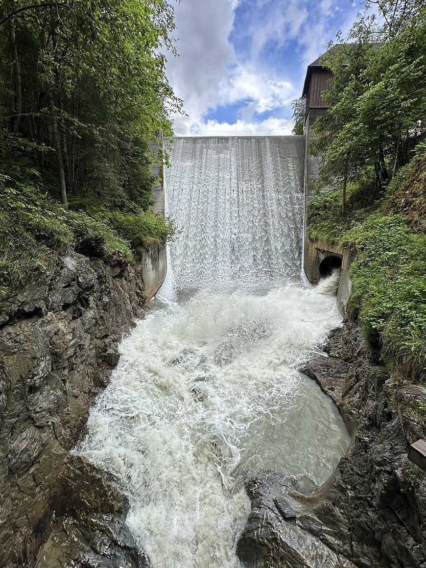 Powerful waterfall cascading from dam into rocky river gorge