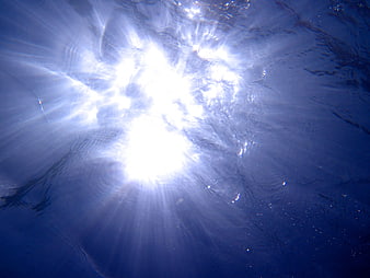Underwater Sun Rays Illuminating Deep Blue Ocean Water Surface