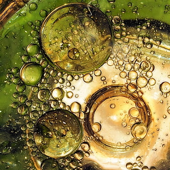 Abstract macro shot of green and gold oil bubbles in water