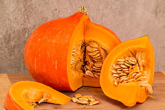 Fresh Hokkaido Pumpkin Cut Open with Seeds on Wooden Board