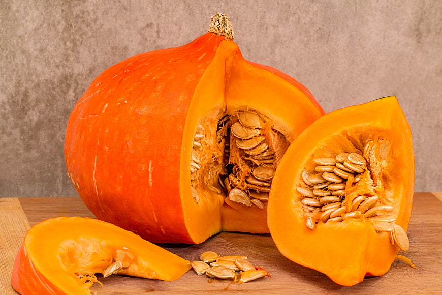 Fresh Hokkaido Pumpkin Cut Open with Seeds on Wooden Board