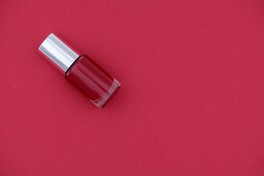 Red Nail Polish Bottle On Pink Background