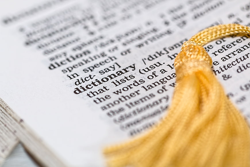 Close-up of dictionary page with yellow tassel bookmark