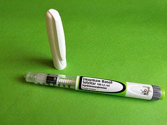 Insuman Basal SoloStar insulin pen with cap on green background
