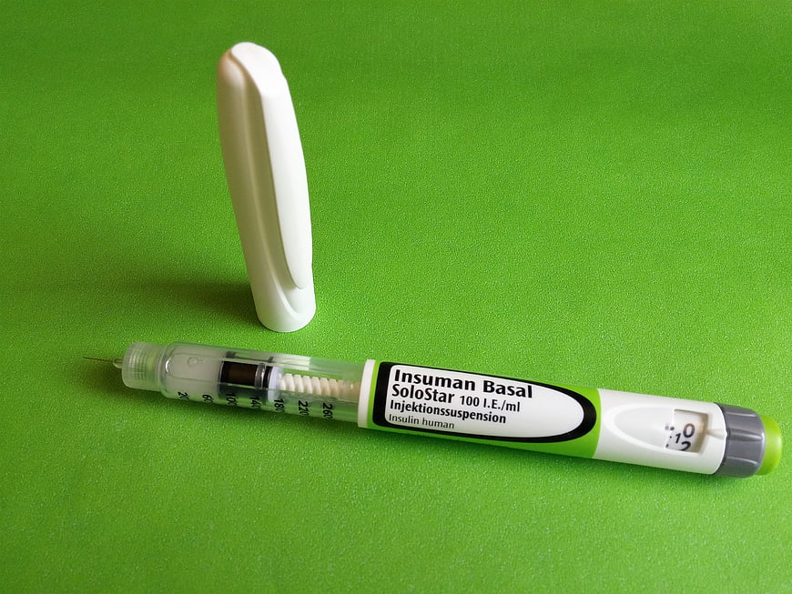 Insuman Basal SoloStar insulin pen with cap on green background