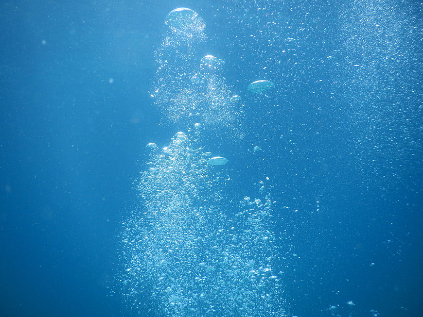 Underwater Bubbles Rising in Blue Ocean Water