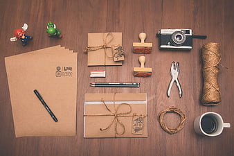 Flat lay of craft supplies, vintage camera, and coffee on wood