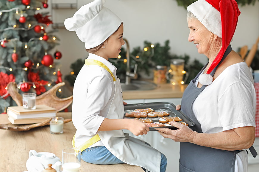Grandmother and granddaughter baking Christmas cookies together in kitchen