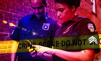 Police Officers Examining Smartphone at Crime Scene