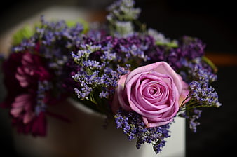 Close-up of pink rose and purple statice bouquet