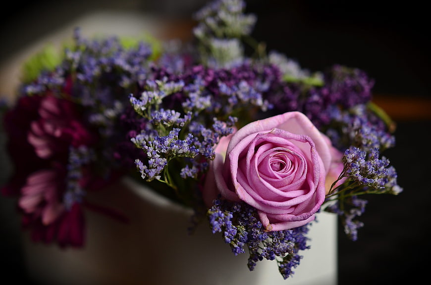 Close-up of pink rose and purple statice bouquet