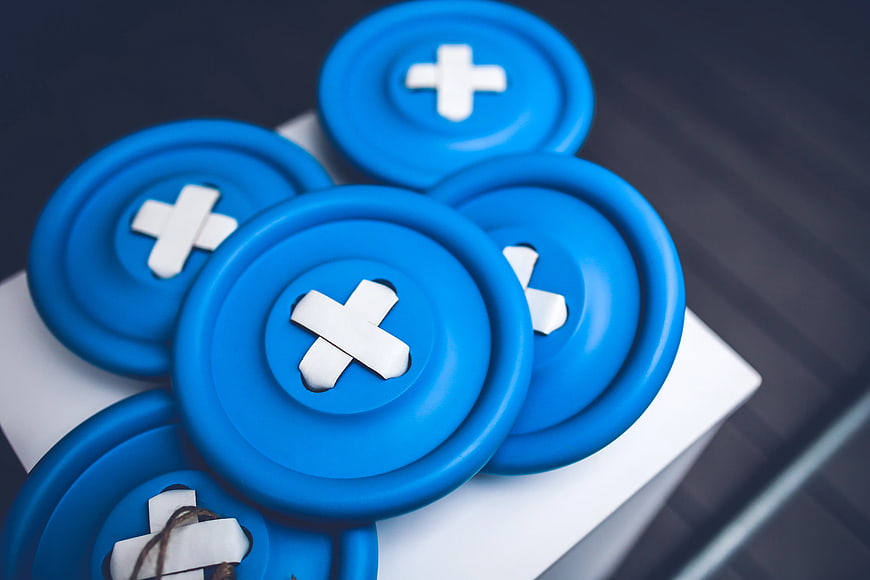 Blue medical buttons with white crosses on white box
