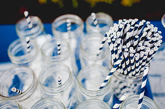 Blue and white striped paper straws in glass jars