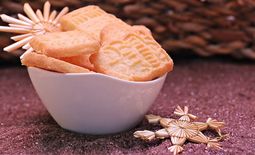 Traditional German Spekulatius Cookies in White Bowl with Straw Stars