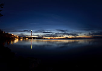 Serene Night Skyline with Tower Reflection on Calm Water