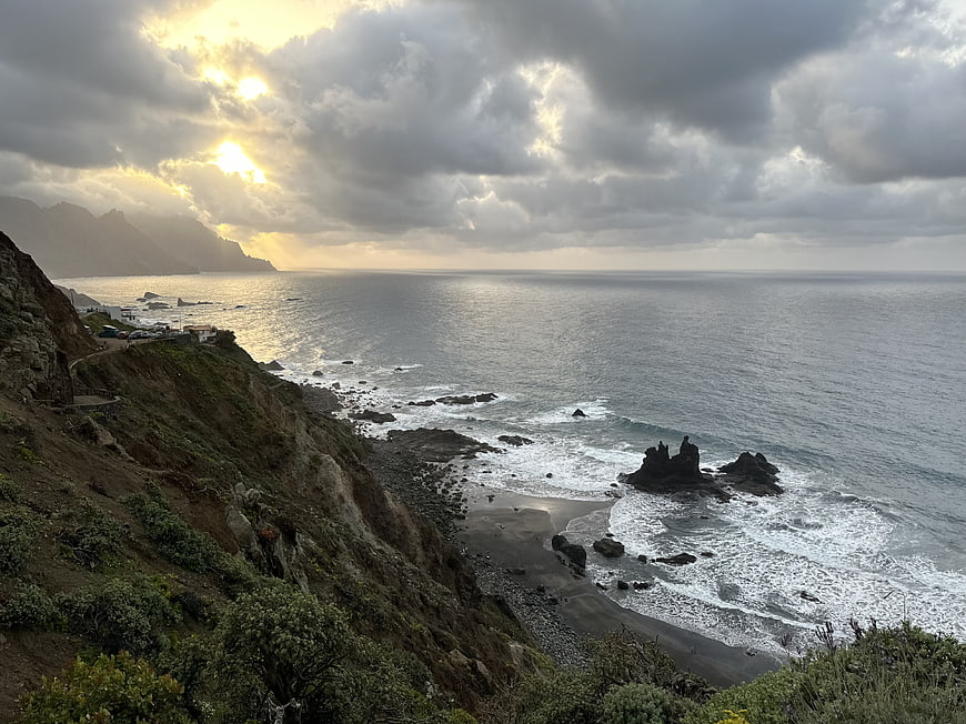 Dramatic Coastal Landscape with Sunlight Breaking Through Clouds