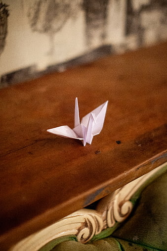 White Origami Crane on Vintage Wooden Table